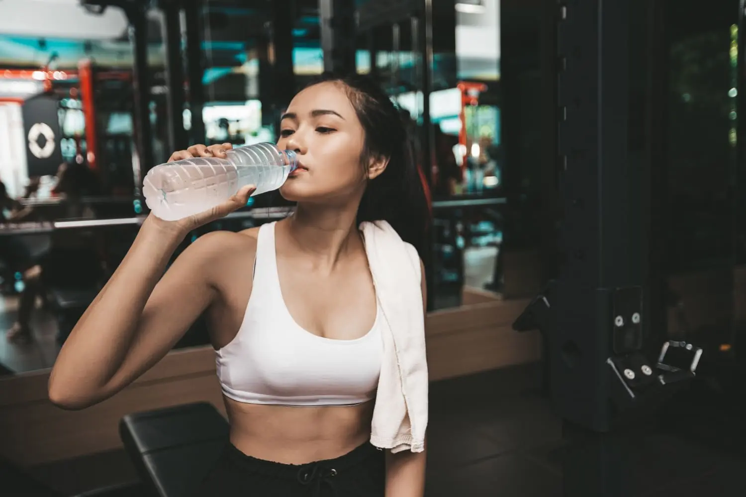Mulher se hidratando após o treino para acelerar o efeito seca barriga